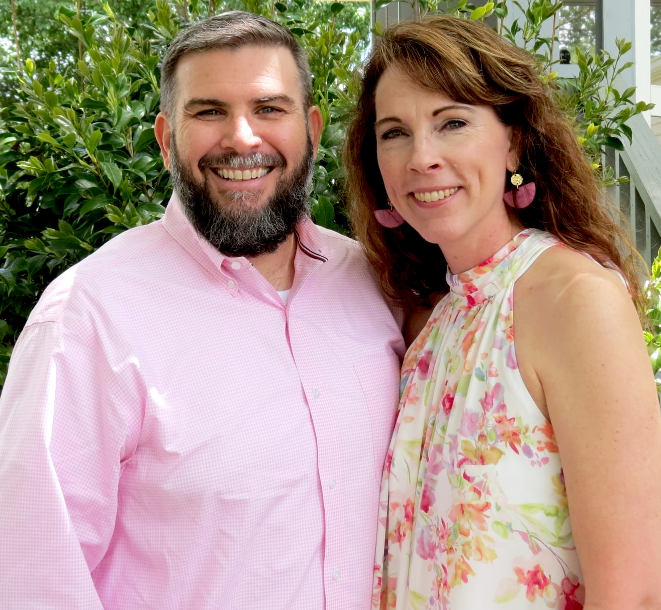 Man and woman standing together in pink against green background